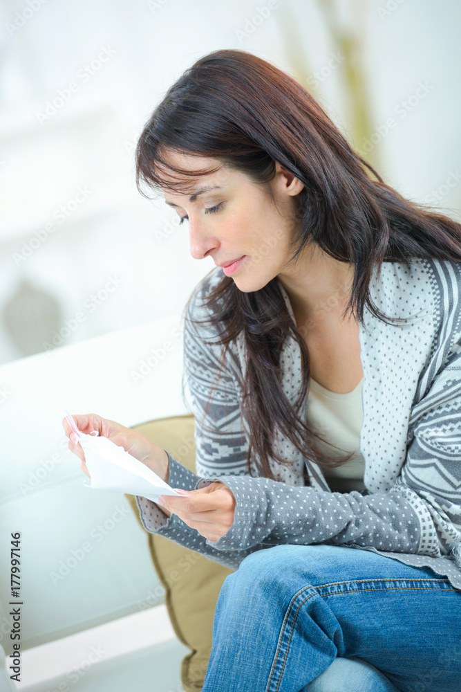 beautiful woman on a sofa reading a paper beautiful woman on a sofa reading a paper