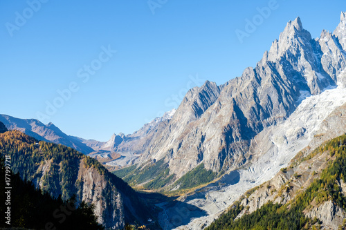 View of mountain peaks, of the Mont Blanc massif and coniferous forests in autumn, Val Ferret, Aosta valley, Italy