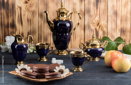 coffee on the table with background with cakes and apples