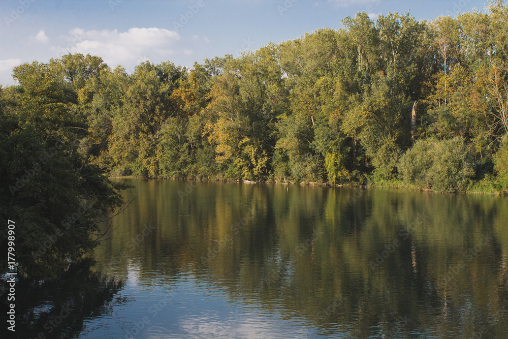Adda river with trees reflected in the water and clear sky Adda river with trees reflected in the water and clear sky