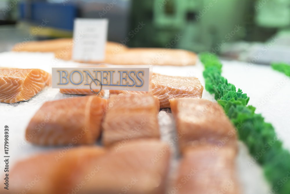 Close up of salmon fillets spread over ice on a fish monger’s market stall in England, UK Close up of salmon fillets spread over ice on a fish monger’s market stall in England, UK