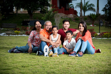 closeup photograph of Indian extended family sitting outdoors smiling

