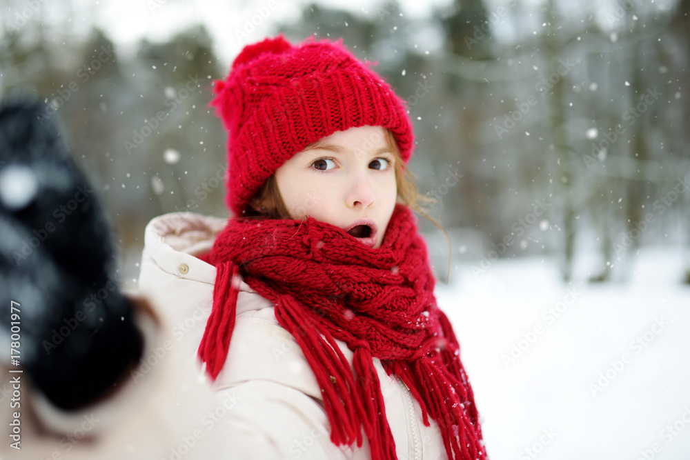 Adorable little girl having fun in beautiful winter park. Cute child playing in a snow. Adorable little girl having fun in beautiful winter park. Cute child playing in a snow.