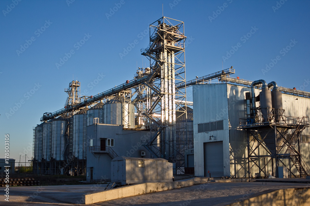 Grain drying complex. Modern grain elevator with silos in agriculture zone Grain drying complex. Modern grain elevator with silos in agriculture zone