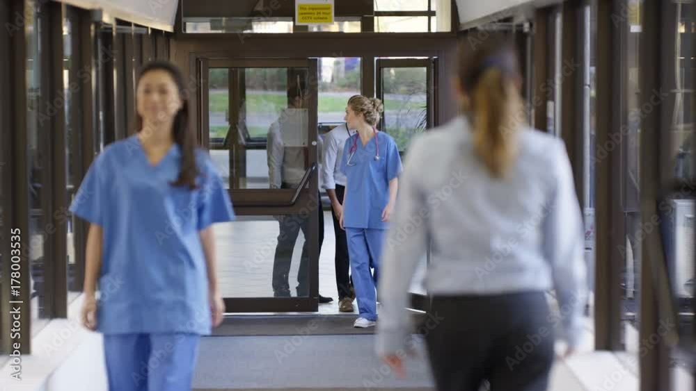 Medical team having a discussion as they walk through hospital hallway Medical team having a discussion as they walk through hospital hallway