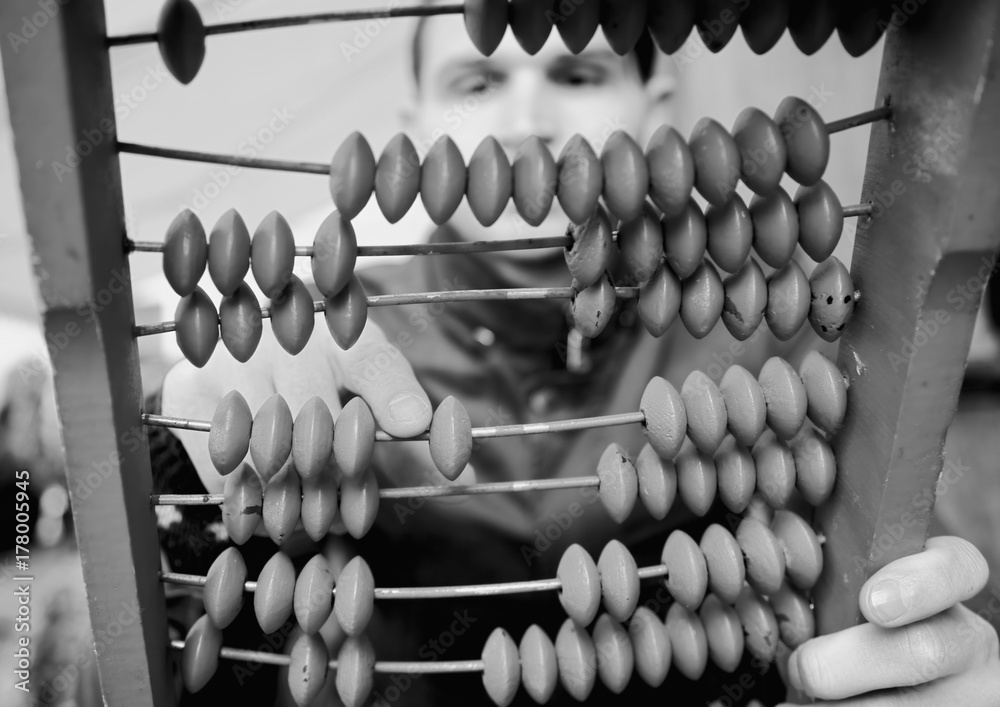 Old fashioned calculator. Young man counting with old abacus as symbol of business and accounting. Old fashioned calculator. Young man counting with old abacus as symbol of business and accounting.