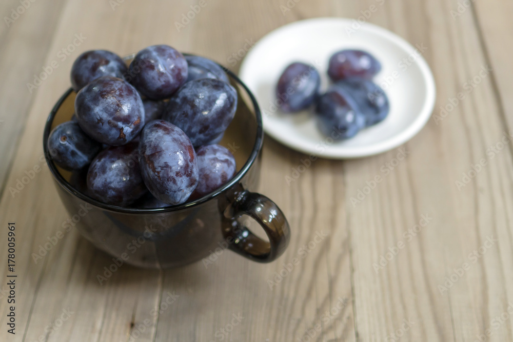 blue plum lies in a glass on a table blue plum lies in a glass on a table