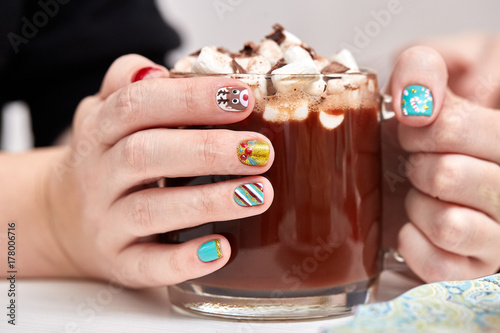 Mug with cocoa and marshmallows in female hands.