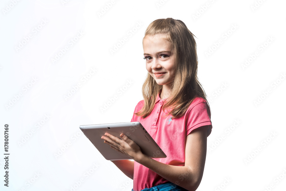 Beautiful little girl with a tablet computer in hands on a white background. Emotions of the child. Beautiful little girl with a tablet computer in hands on a white background. Emotions of the child.