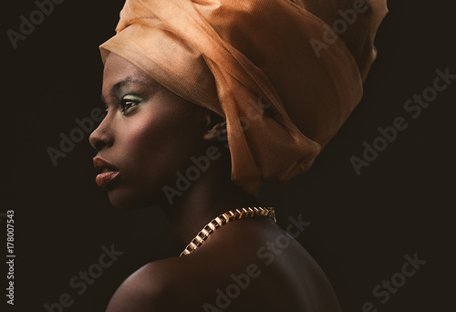 Studio shot of young woman with orange turban photo