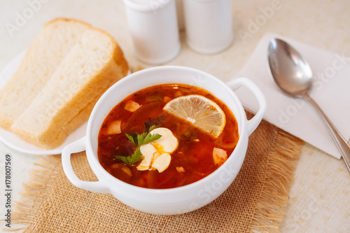 Meat Soup Solyanka, on a wooden table. photo