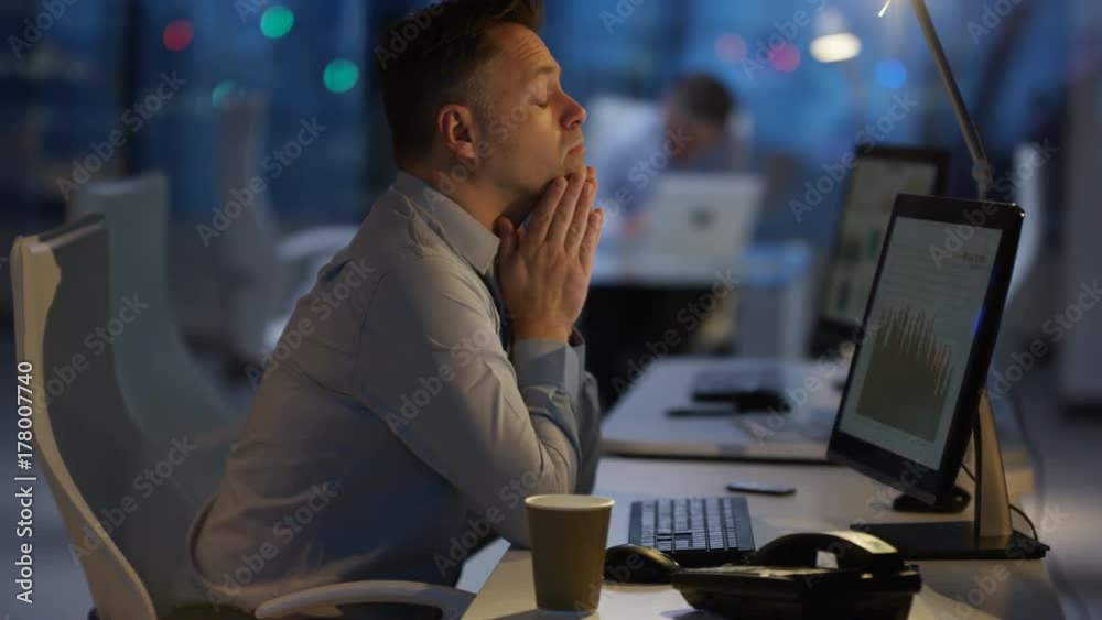  Exhausted businessman working late at the office