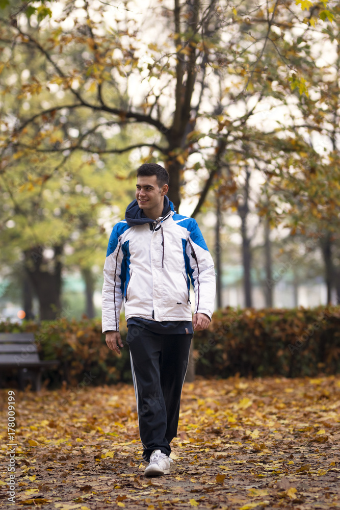 Young male tourist walking and looking at right in the street at autumn