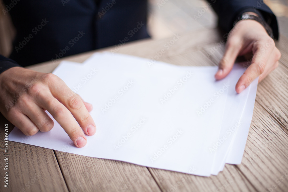 An empty business contract, close-up. Hands of a businessman in a jacket. An empty business contract, close-up. Hands of a businessman in a jacket.