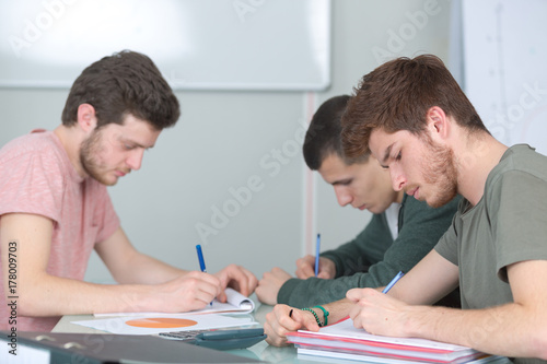 3 male young students studying together photo