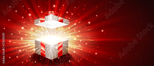 Open gift box with a shining exploding firework of glitters and radial zoom of light rays. Greeting banner for Christmas, New Year, Birthday. Vector illustration are proportion to 8.5x3.66 flyer size