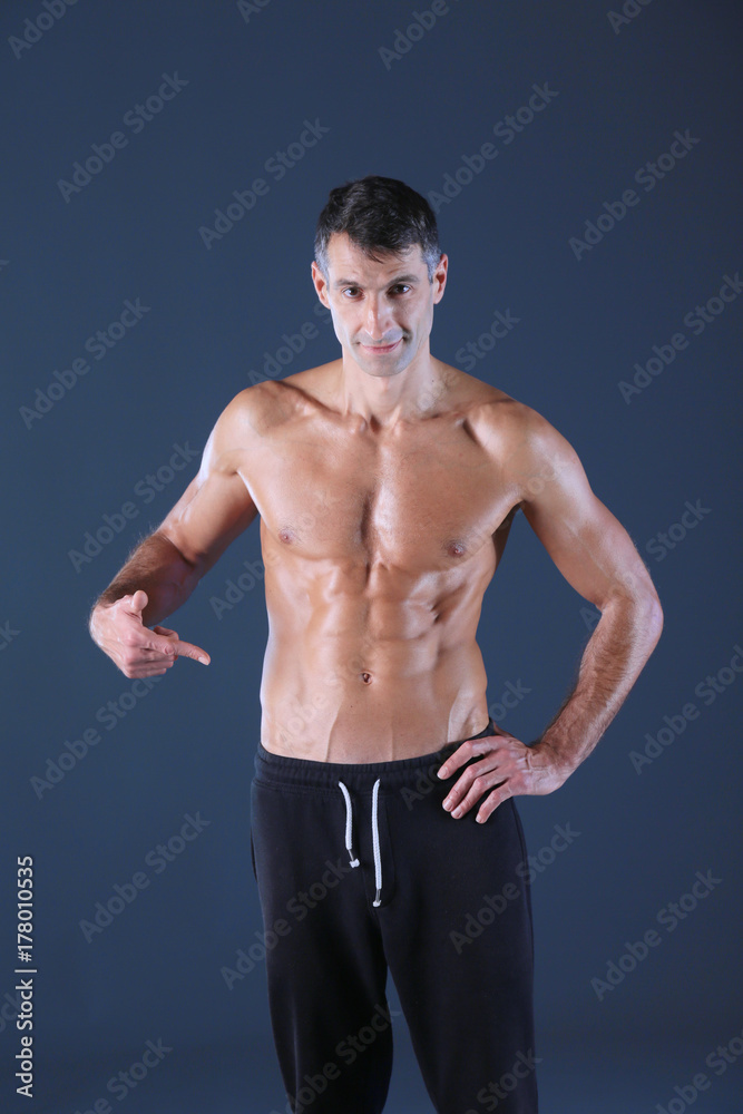 muscular man. Muscular man on a grey background showing muscles. Fitness instructor. Fitness professional. Workout. Men's fitness.