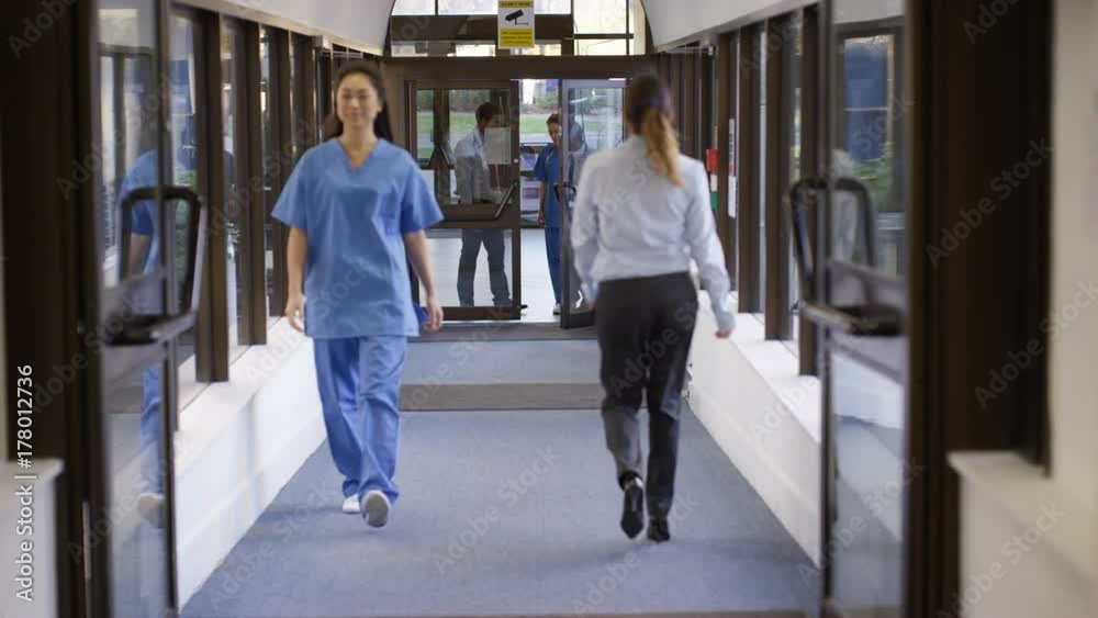  Medical team having a discussion as they walk through hospital hallway