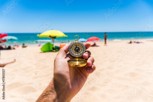 Hand with compass at the beach. summer time