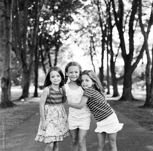 Black and white portraits of dorable siblings standing in an alleyway photo