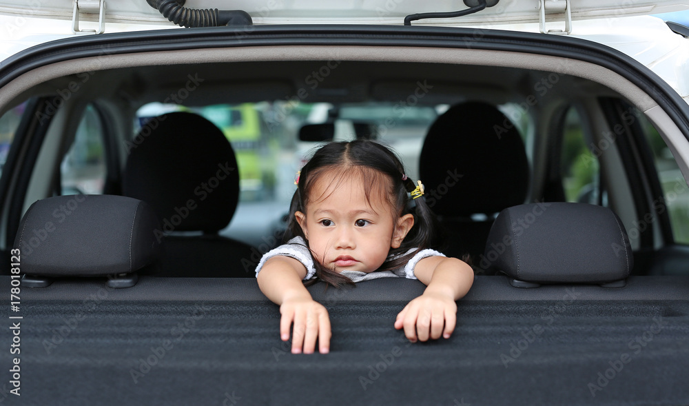 Little asian child looking camera from the hatchback door of the car. Little asian child looking camera from the hatchback door of the car.