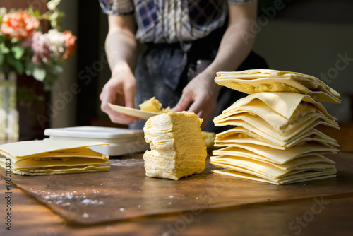 Raw puff pastry dough on wooden table photo