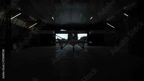 Group of people opening doors of hangar, view from inside. photo