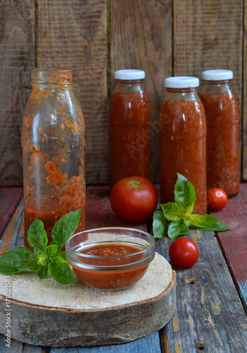 Jars of tomato sauce with chili, pepper and basil. Bolognese sauce, passata, lecho or adjika. Preservation. Canning.