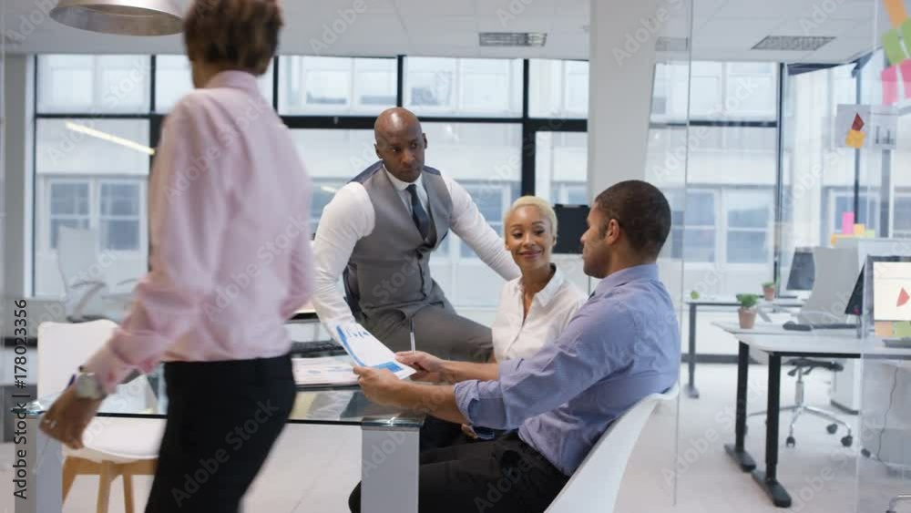 African American business team in a meeting looking at graphs and data on computer screen. African American business team in a meeting looking at graphs and data on computer screen.