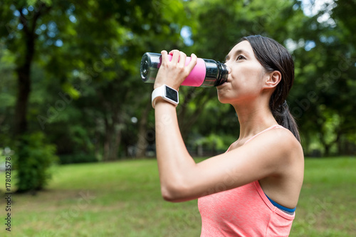 Sport woman drink of water in park