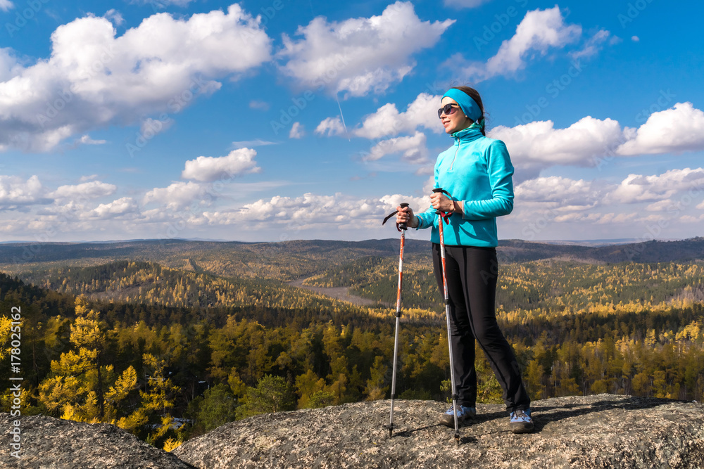 The hiker girl is standing on the edge of a cliff