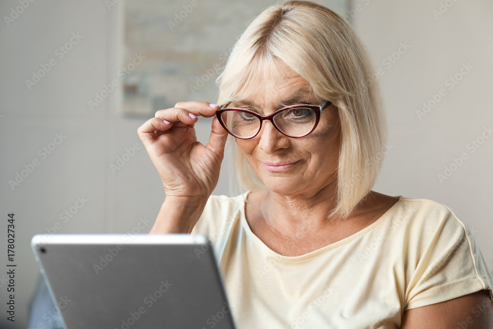 Mature woman using tablet computer at home Mature woman using tablet computer at home