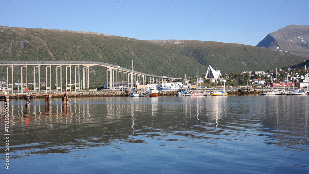 Tromso city and Ishavskatedralen panorama reflected in a fjord, north of Norway