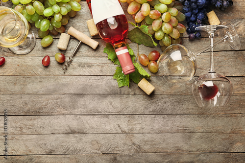 Composition with wine and grapes on wooden background photo