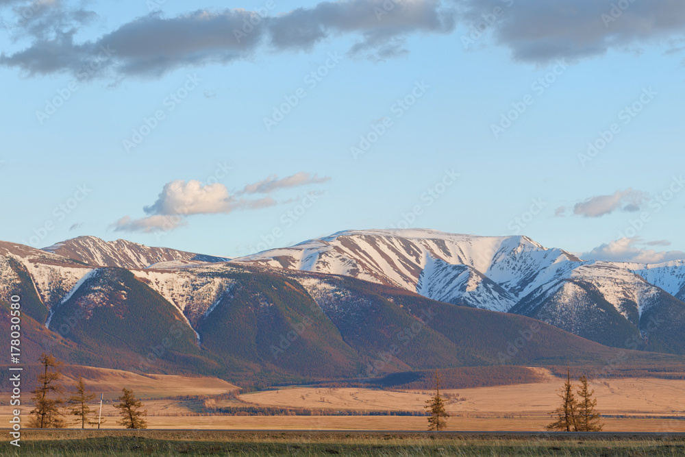 Fototapeta premium panoramic view of plain at root of great mountains with snowy tops 