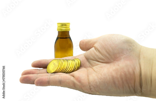drug opaque glass bottles and stack of coin handle by man hand in budget cost money concept spend to health on isolated white background with clipping path