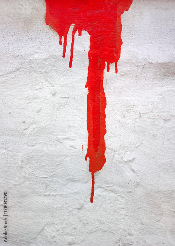 red paint dripping on a concrete wall
