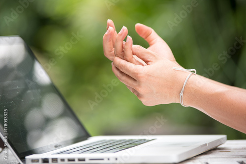 woman painful finger due to prolonged use of keyboard and mouse.