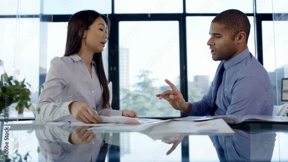  Business manager reprimanding female member of staff in office meeting