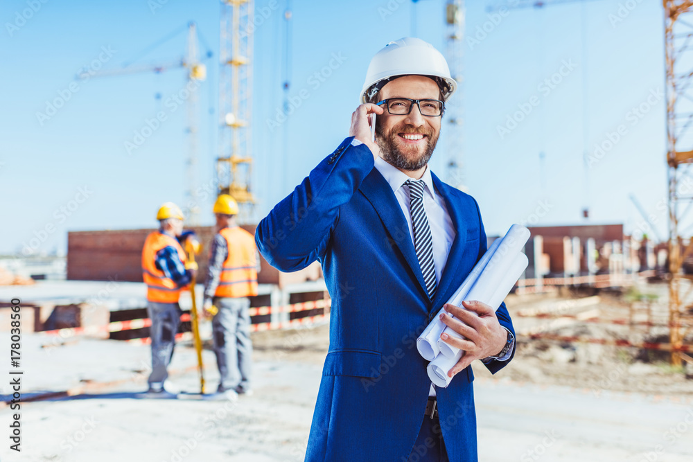 Businessman talking on phone at construction site Businessman talking on phone at construction site