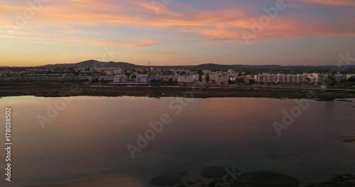 Aerial sunset and historic life-guard building at Fuseta fishing town, in Ria Formosa wetlands nature conservation park, Algarve. Portugal