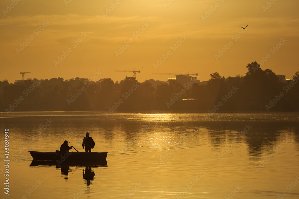 Fishermen fishing on a lake at sunrise