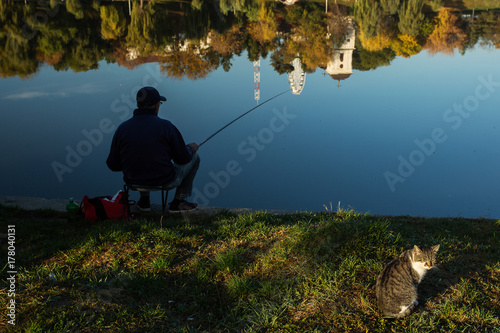 People fishing in a park in autumn season with colourful leafs
