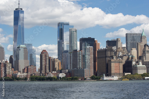 Urban New York American landscape from ocean (among water) with skyscrapers and blue sky with contrast clouds on background