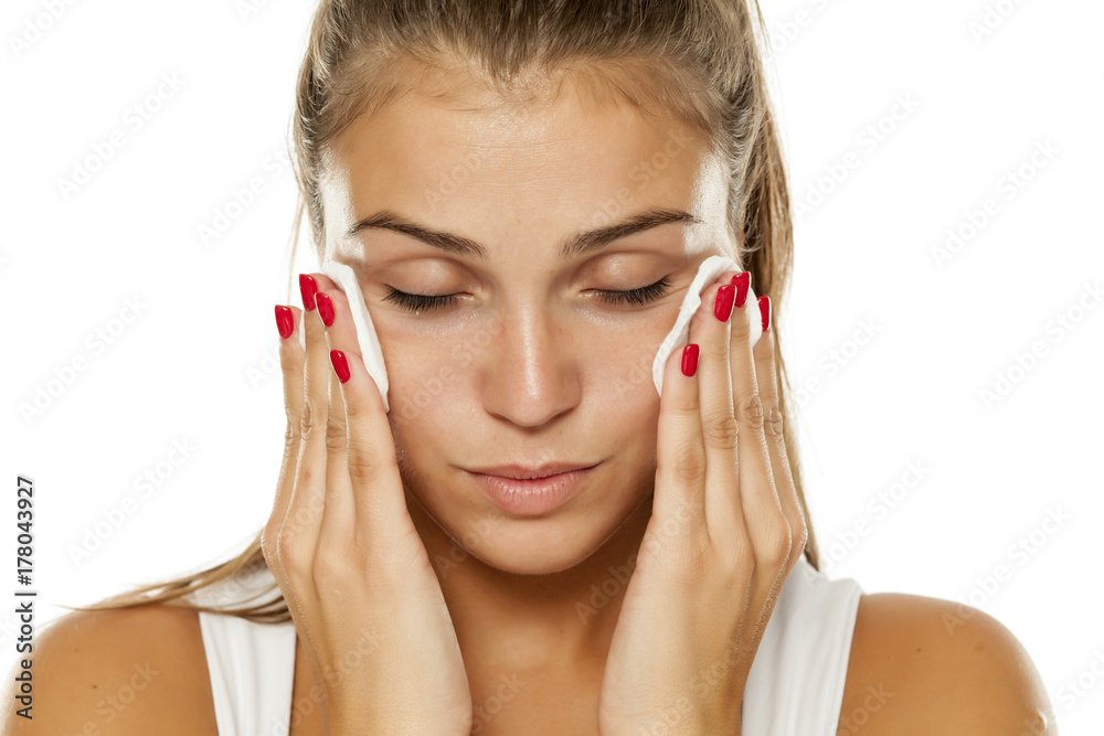 young beautiful woman removing makeup from her face young beautiful woman removing makeup from her face