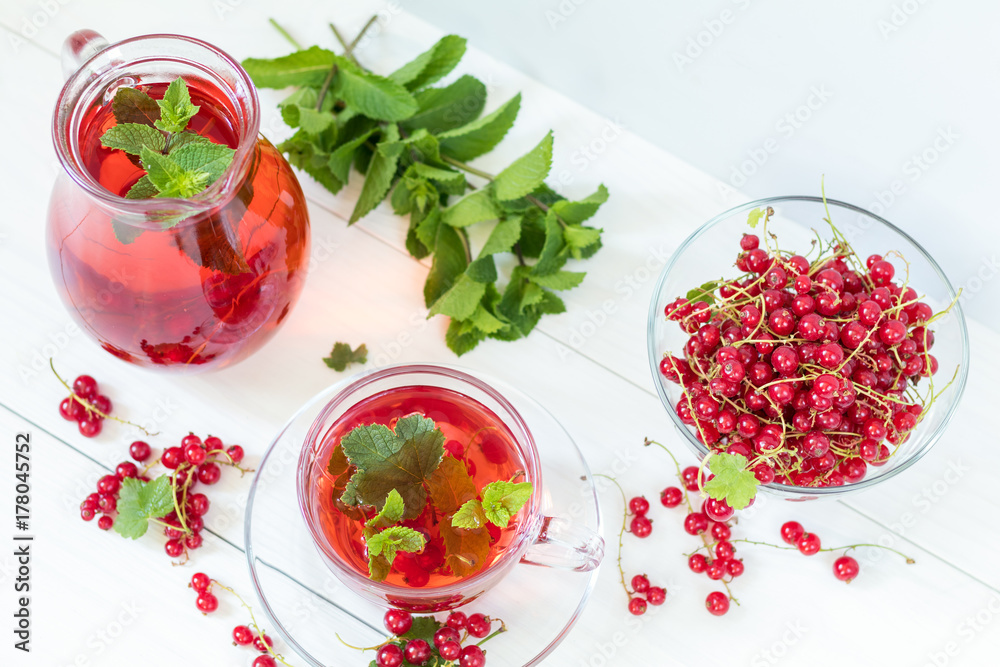 Redcurrant drink in transparent glass carafe and cup Redcurrant drink in transparent glass carafe and cup