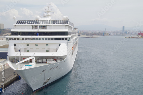 Front view of modern white MSC cruiseship or cruise ship liner with bow and bridge in port of Marseille with city skyline and harbor in background photo