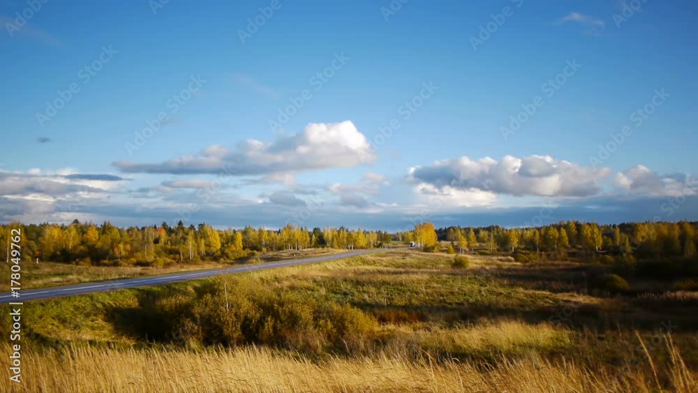 Autumn landscape with road and moving cars Autumn landscape with road and moving cars