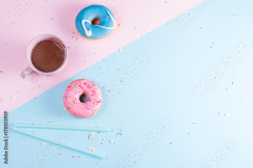 Two sweet doughnutswith cacao on blue and pink background with copy space