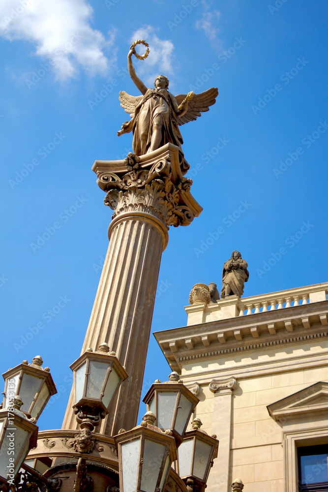 Statue of an angel on a pillar / Neo-Renaissance sculpture towering high on a column